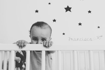 Portrait of baby boy in crib