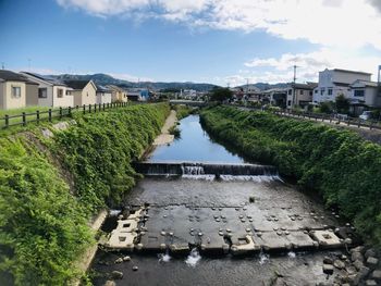 High angle view of river amidst buildings against sky