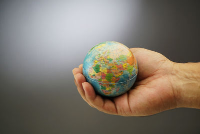 Close-up of human hand against colored background