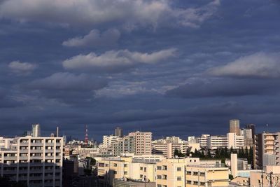 View of cityscape against cloudy sky