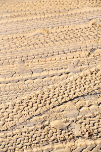 Full frame shot of tire tracks on sand