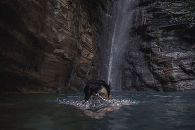 Young man swimming in river