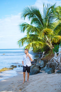 Rear view of woman standing at beach