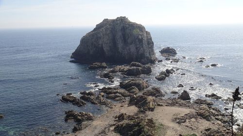 Rocks on sea shore against sky