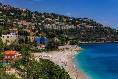 High angle view of townscape by sea against sky