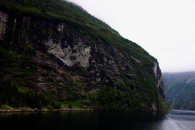 Scenic view of sea by cliff against sky