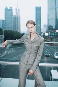 Woman standing by railing in city