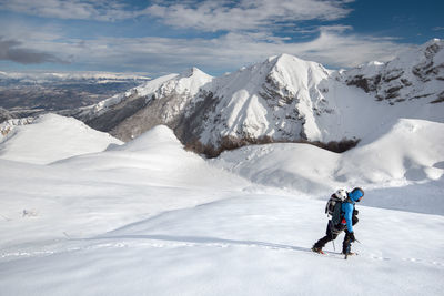 Rear view of people on snowcapped mountains during winter