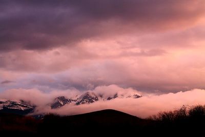 Scenic view of silhouette mountains against dramatic sky