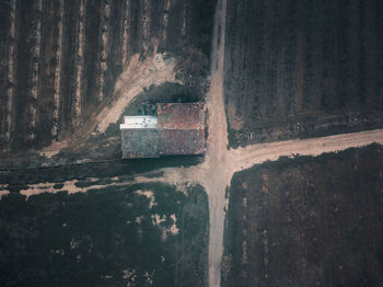 High angle view of farm house next to dirt road crossing