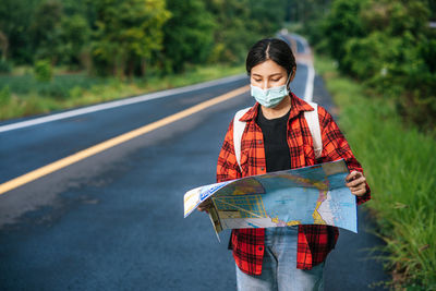 Young woman standing on road