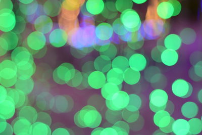 Defocused image of illuminated green lights at night