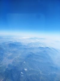 Aerial view of landscape against blue sky