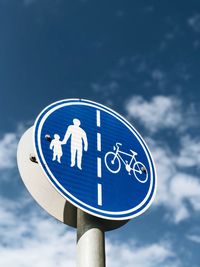 Low angle view of road sign against blue sky