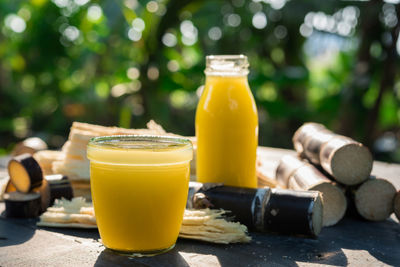 Close-up of sugar cane and juices on table