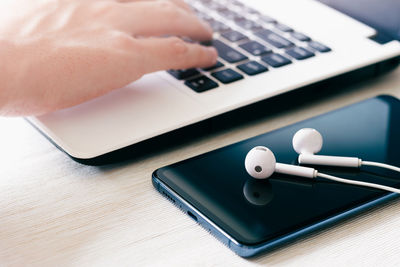 Close-up of hand using laptop on table