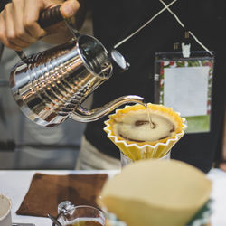 Midsection of man preparing coffee in cafe