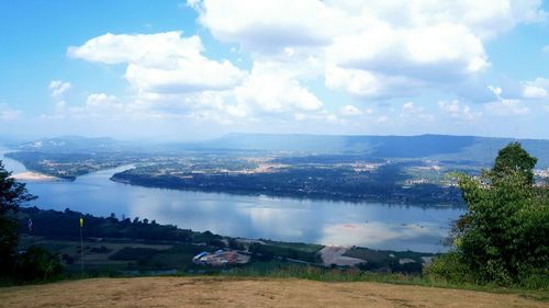 Scenic view of river by mountains against sky