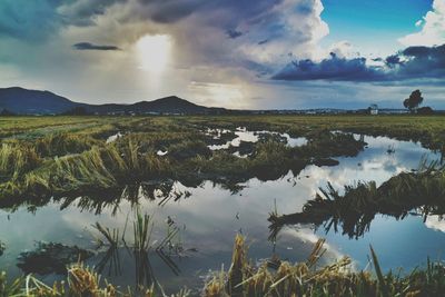 Scenic view of lake against cloudy sky