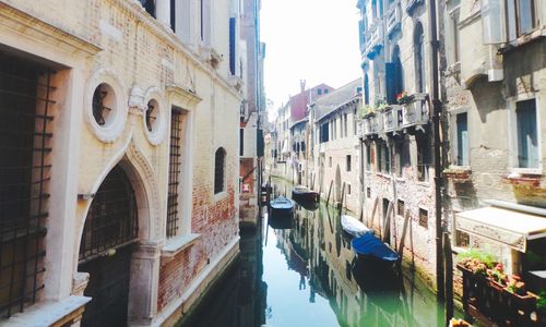 Boats in canal along buildings