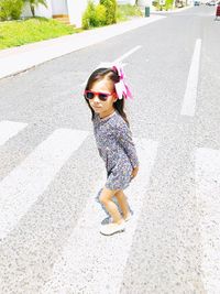 Full length of girl wearing sunglasses while walking on road