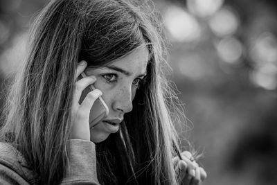 Portrait of young woman looking away outdoors