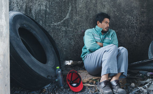 Young man sitting on wall