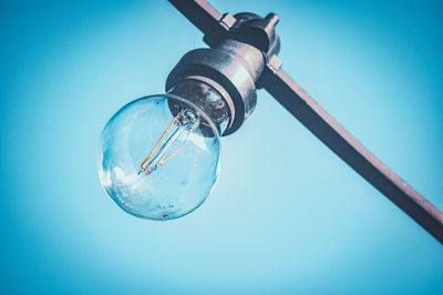 Low angle view of street light against blue sky