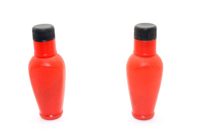 Close-up of red wine bottles against white background
