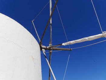 Low angle view of telephone pole against clear blue sky