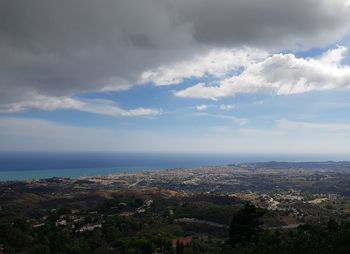 Aerial view of city by sea against sky