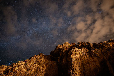 Low angle view of rock formation against sky at night