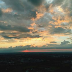Scenic view of sea against cloudy sky at sunset
