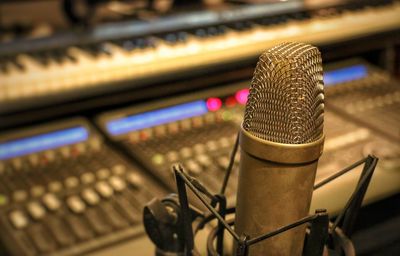 Close-up of microphone against sound mixer in recording studio