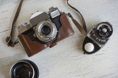 High angle view of camera by light meter on table at home