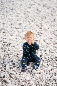 High angle view of baby boy on pebbles