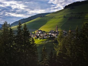 Scenic view of green mountain against cloudy sky