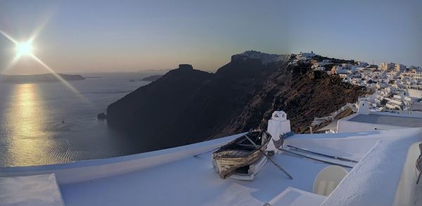 Scenic view of sea by snowcapped mountain against sky during winter