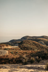 Mountainous landscape with rolling greens and winding road