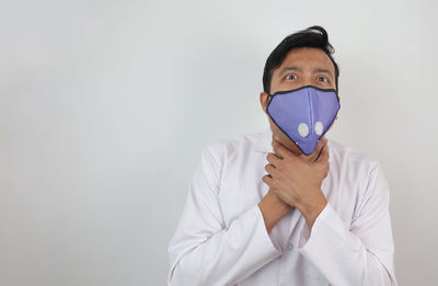 Portrait of man standing against white background