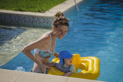 Side view of young woman sitting in swimming pool