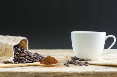 Close-up of coffee cup on table against black background