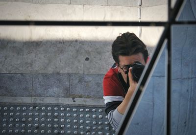 Man holding camera while standing outdoors