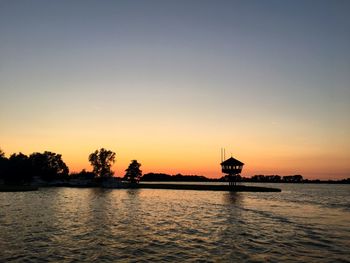 Scenic view of lake against orange sky