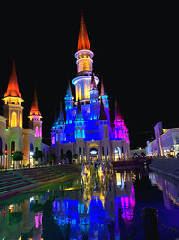 Illuminated buildings against sky at night