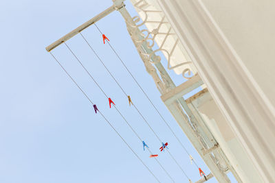 Low angle view of flags hanging against clear sky