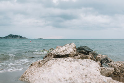 Scenic view of rocks on beach against sky