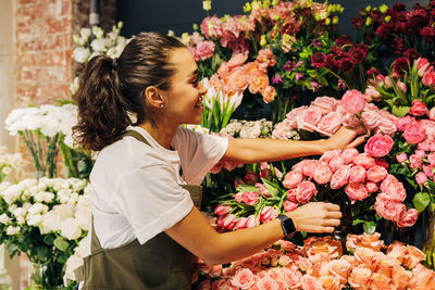 Florist analyzing flowers at shop