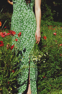 Low section of woman standing in field, next to her poppys