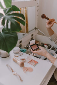 Cropped hand of woman holding make up brush